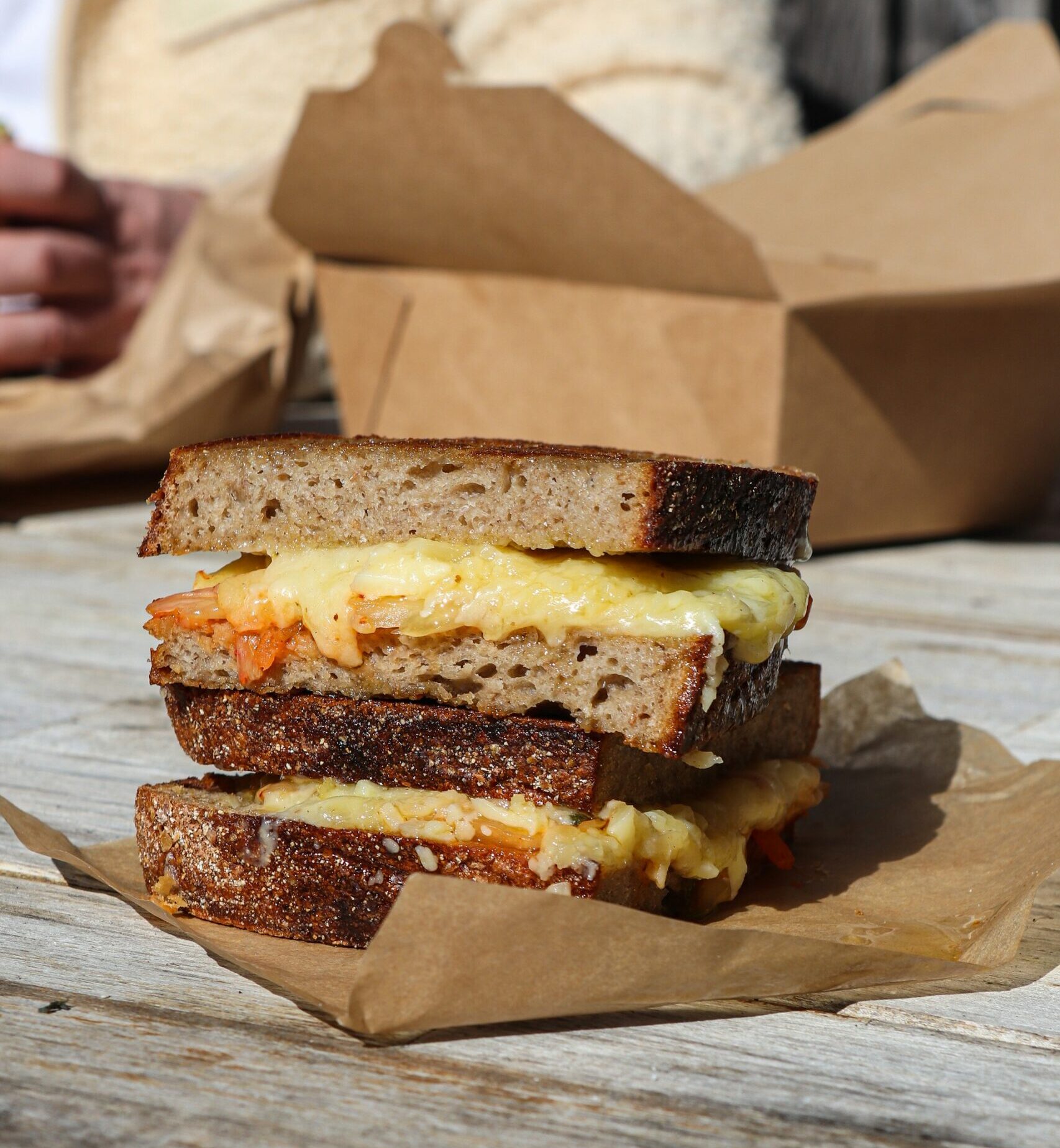 Cheese toastie sandwich cut in half on a piece of paper.